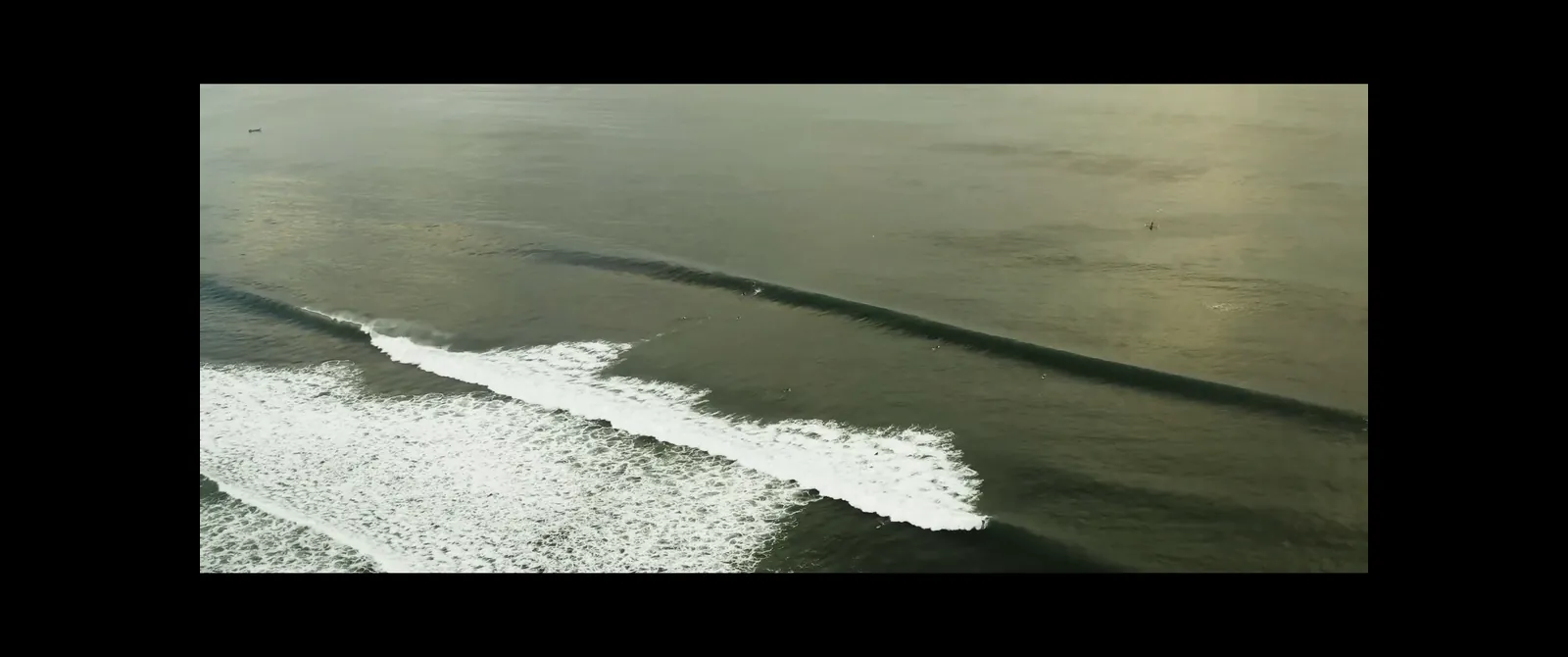 A wide movie with black bars on all sides of an ultrawide monitor