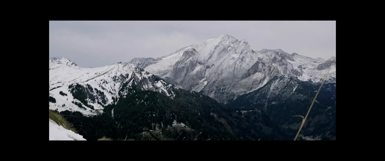 A wide movie with black bars on all sides of an ultrawide monitor